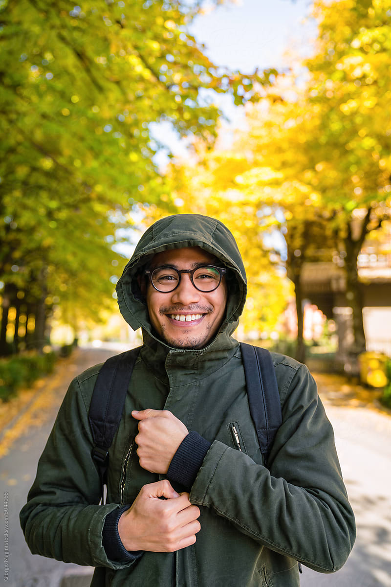 Happy Young Filipino Man Wearing a Parka Outdoors during Autumn