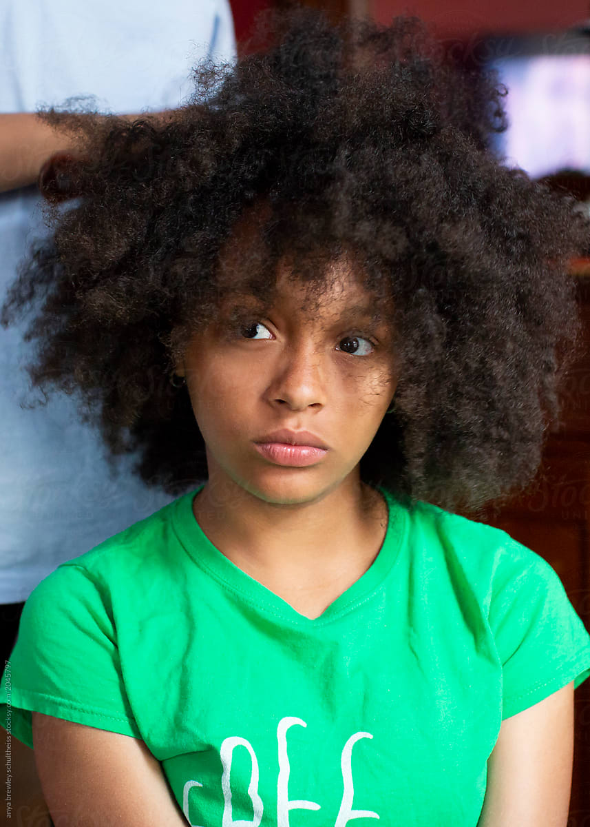 Teen getting her curly hair combed