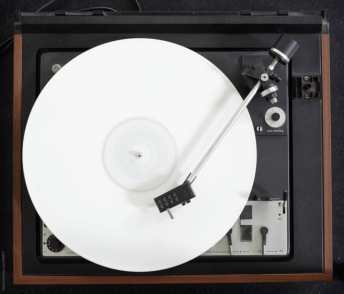 Vintage turntable with a white vinyl album playing