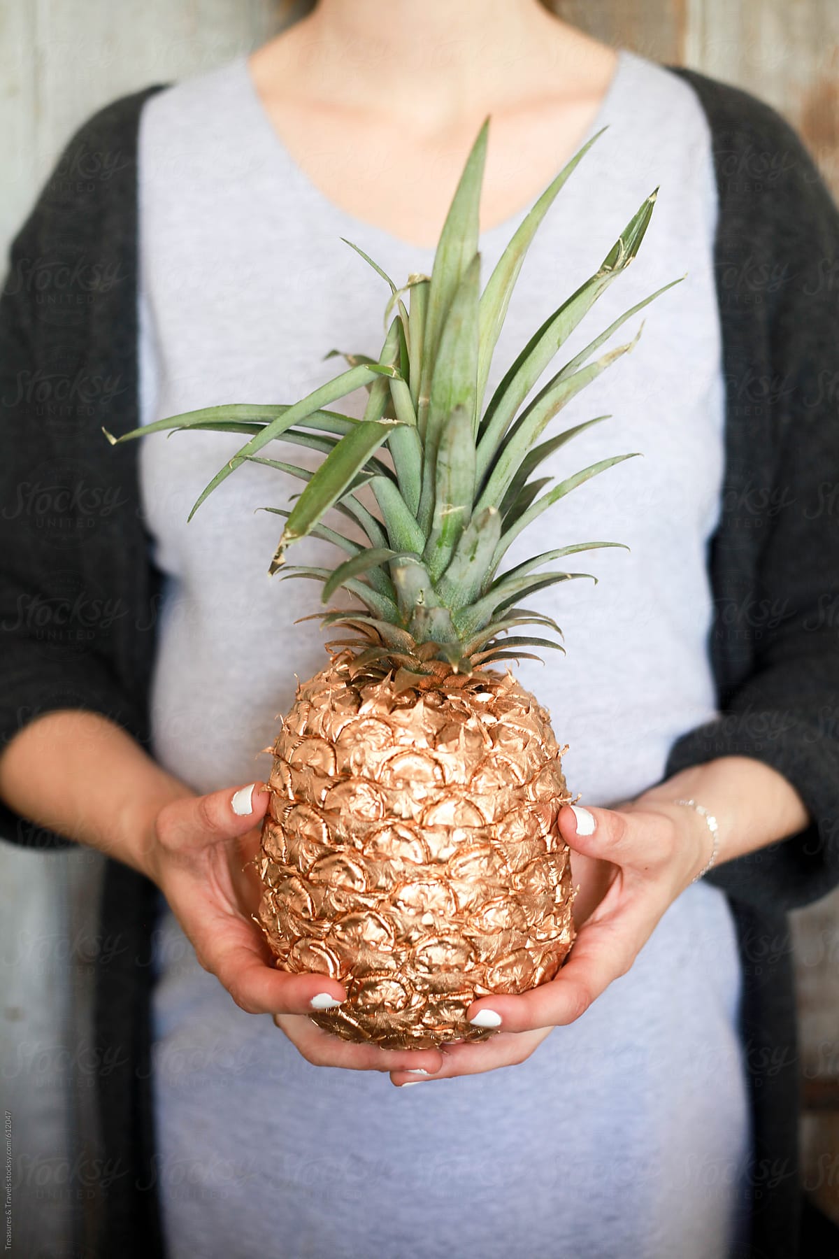 Woman holding a gold pineapple