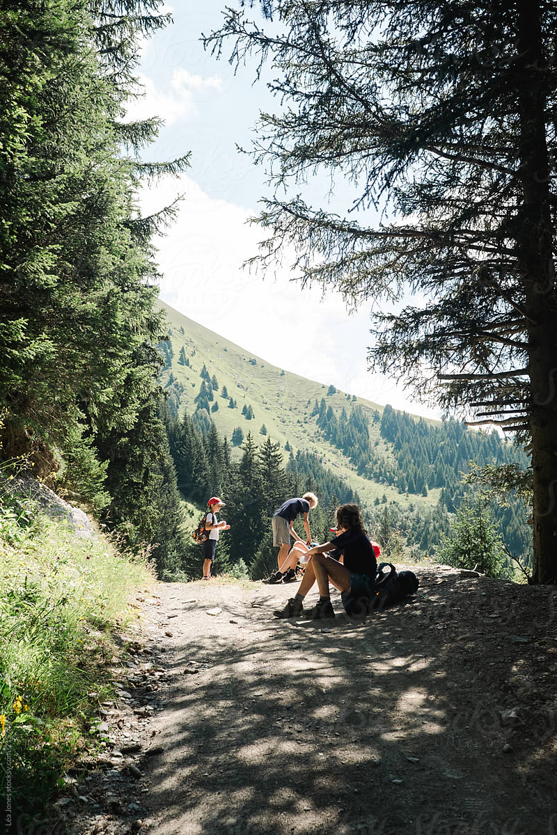 group of kids and teens stopping for a rest during  a hike in the Alps