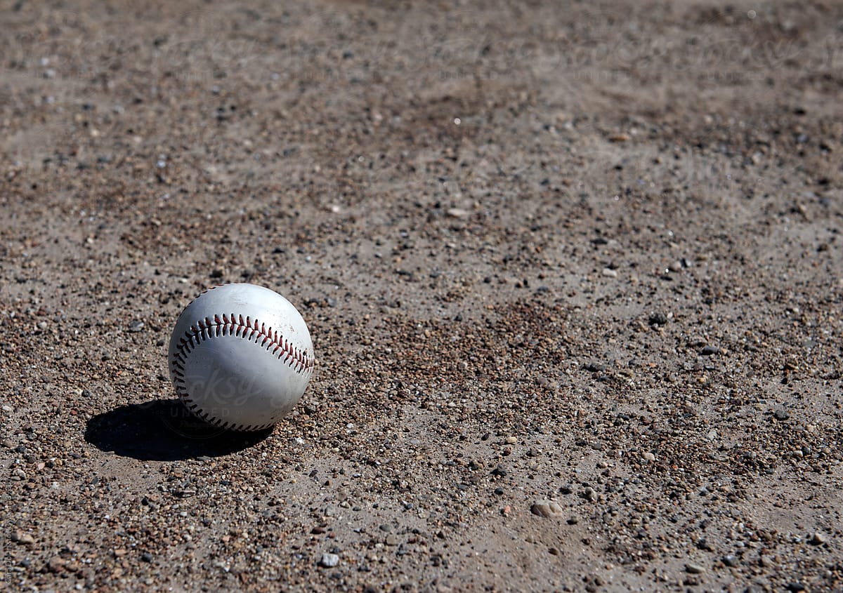 Baseball Sitting on Dirt Field