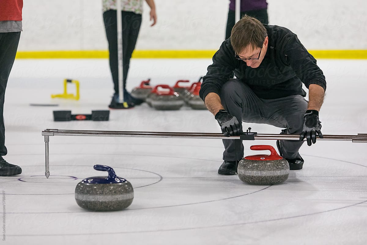 Curling: Man Uses Device To Mesure Closest Stone
