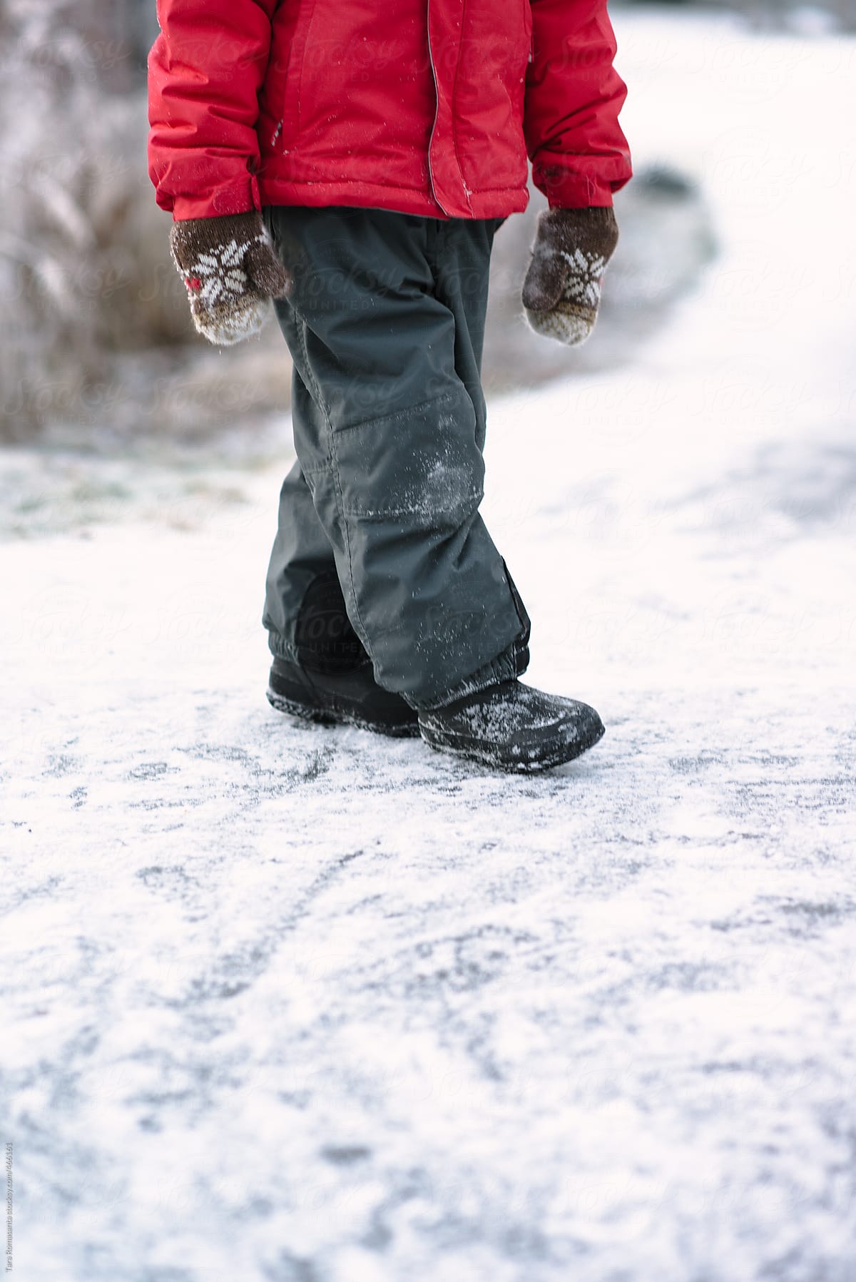 child in snow pants, mittens, boots and winter jacket