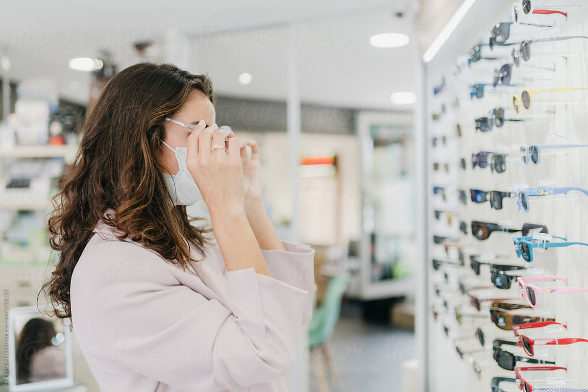 Woman wearing face mask shopping for glasses