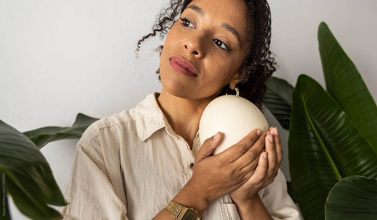 Casual woman studio portrait with ostrich egg