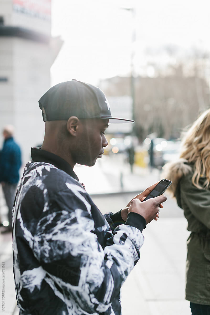 Black Man Using a Smart Phone in the Street