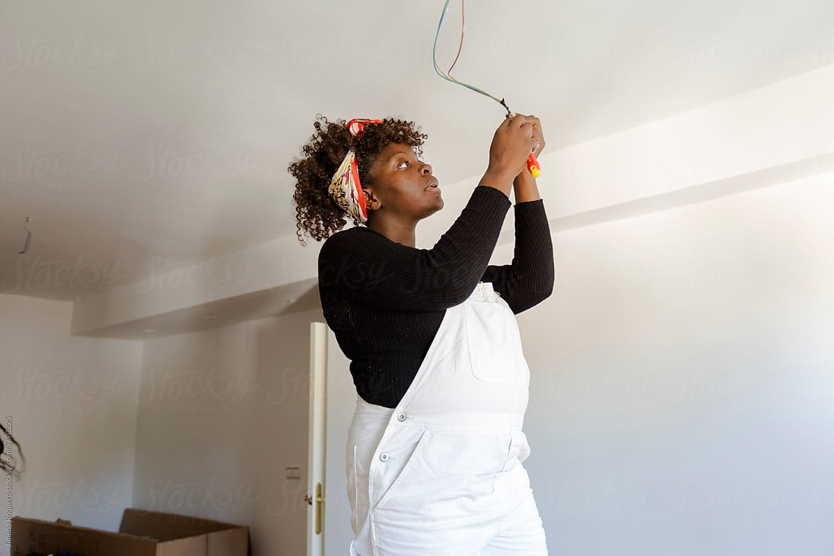 Pregnant woman fixing electric installation in new home
