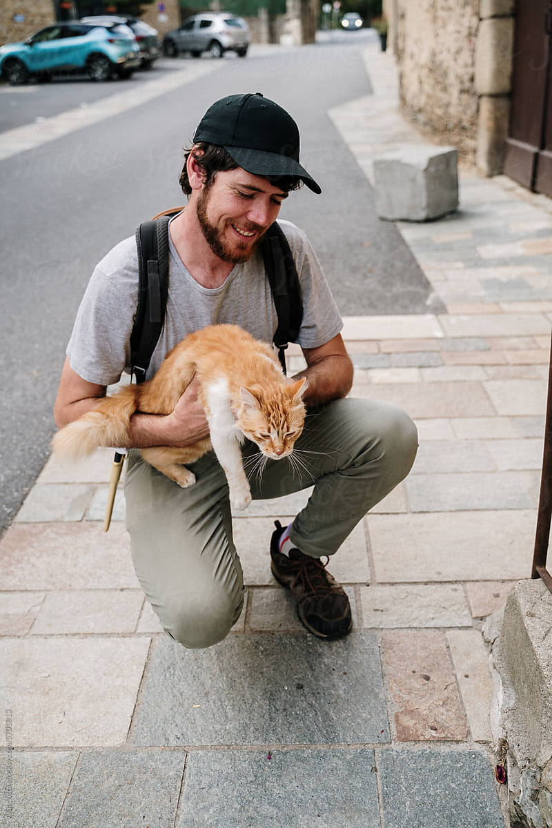 Man petting street cat