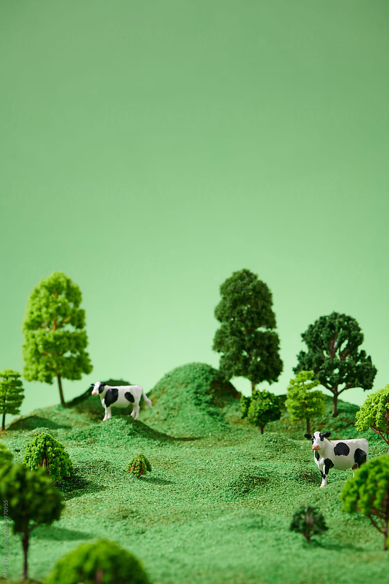 Miniature cows models in green grove
