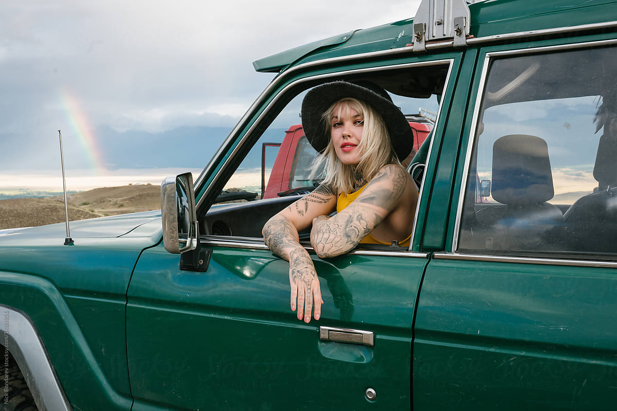 Young Blonde Tattooed Woman Sitting In The Green Car By Nick Bondarev