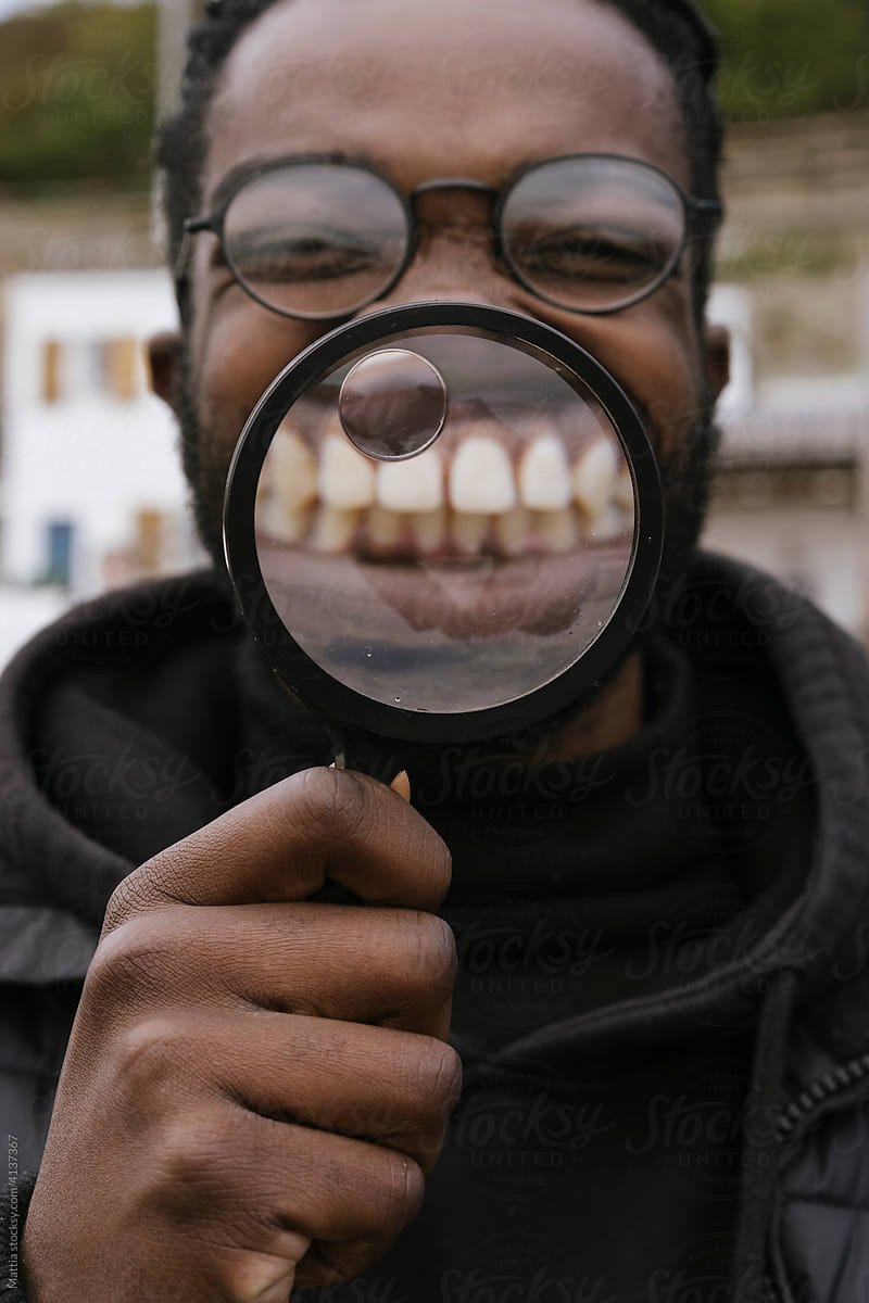 Black Man is Playing with a Magnify Glass