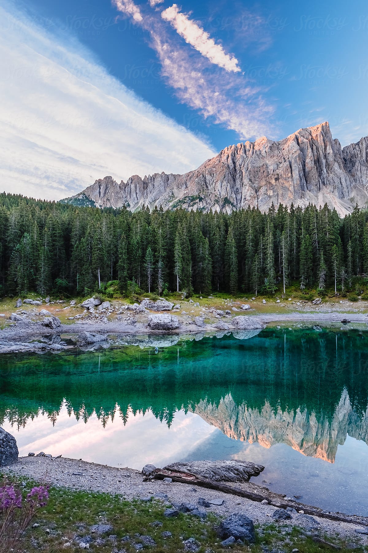 An italian mountain crystal clear lake with mountains at the background and still calm bank at the front