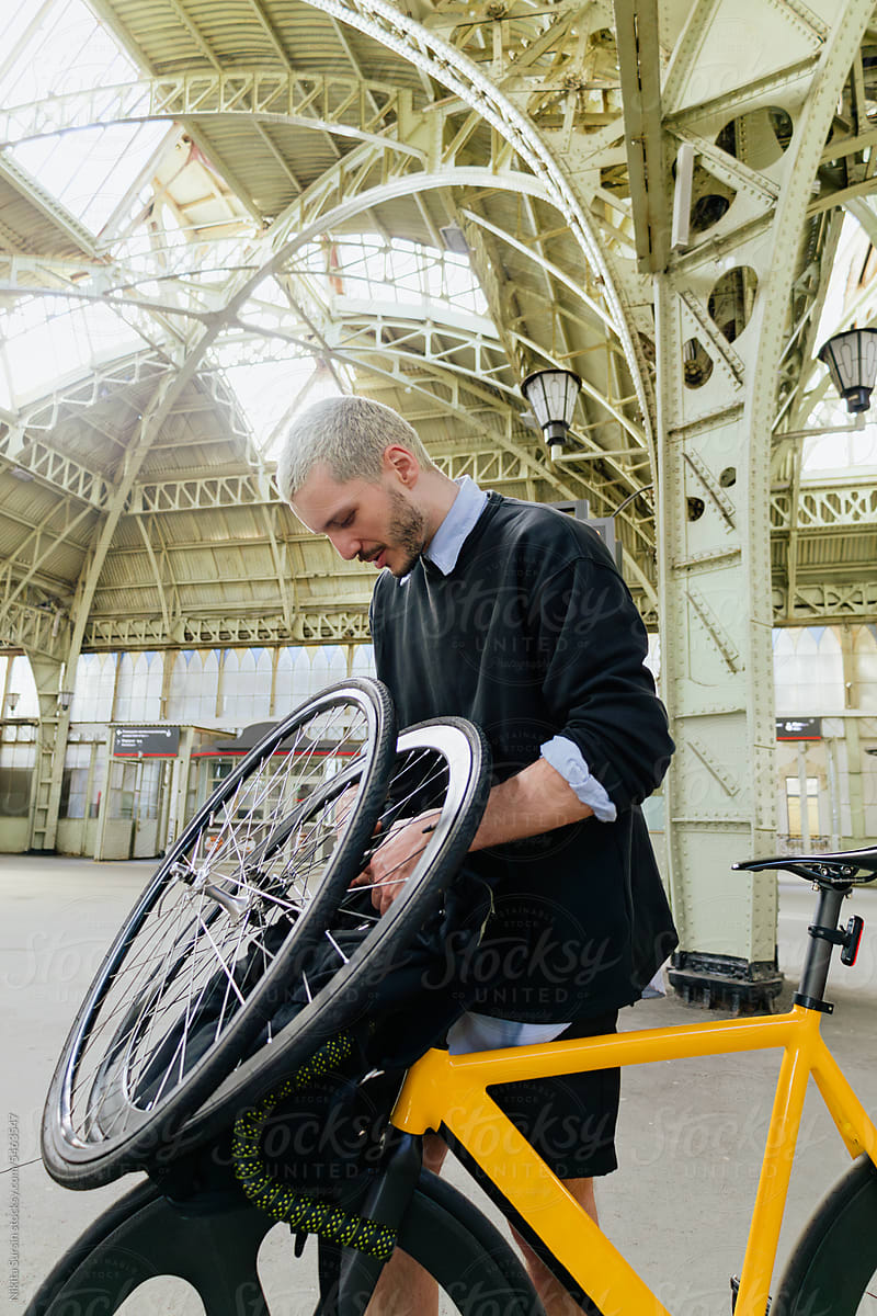 man on bicycle on train station travelling to countryside