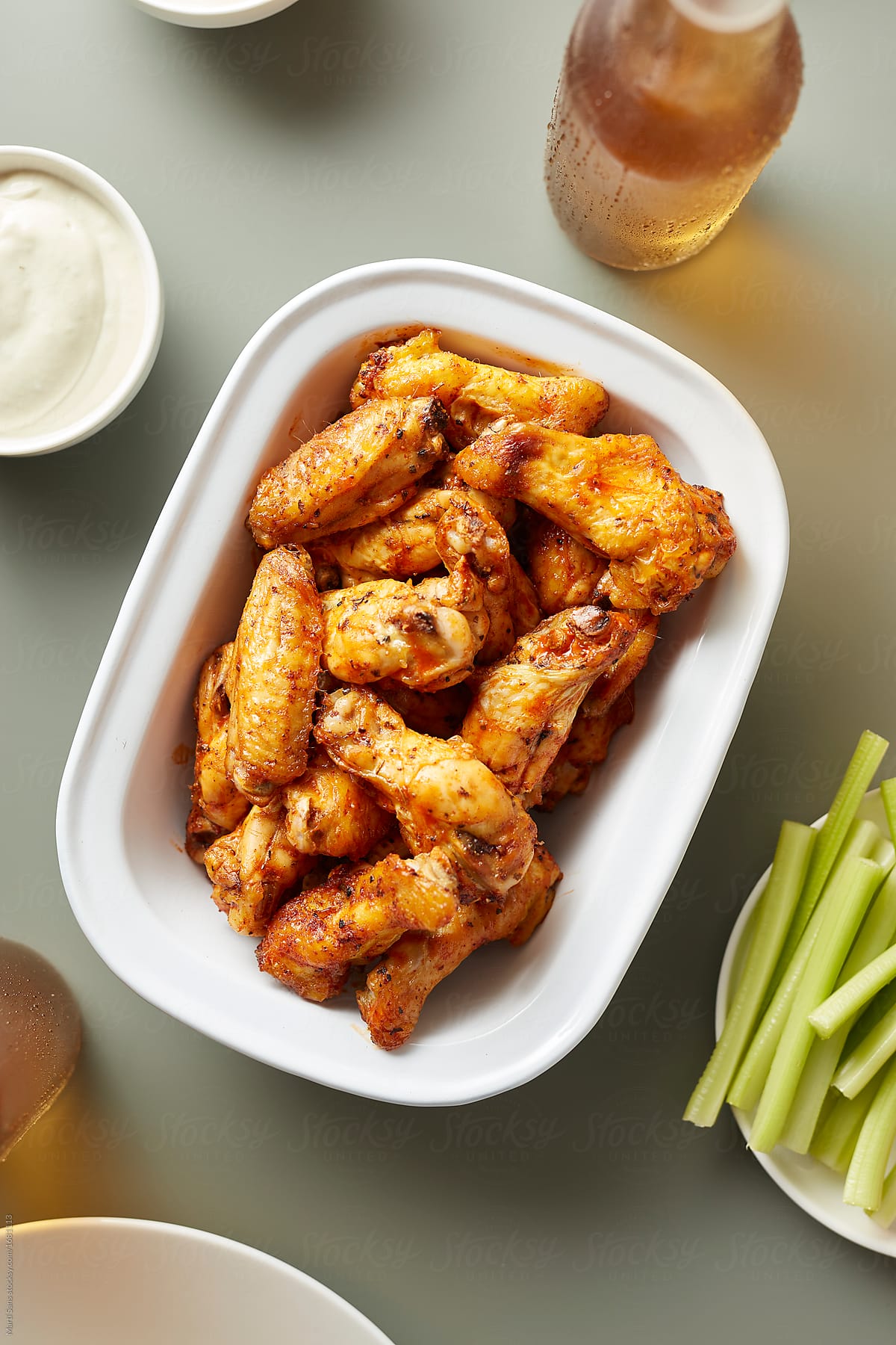 Juicy chicken wings in bowl served with celery and beer