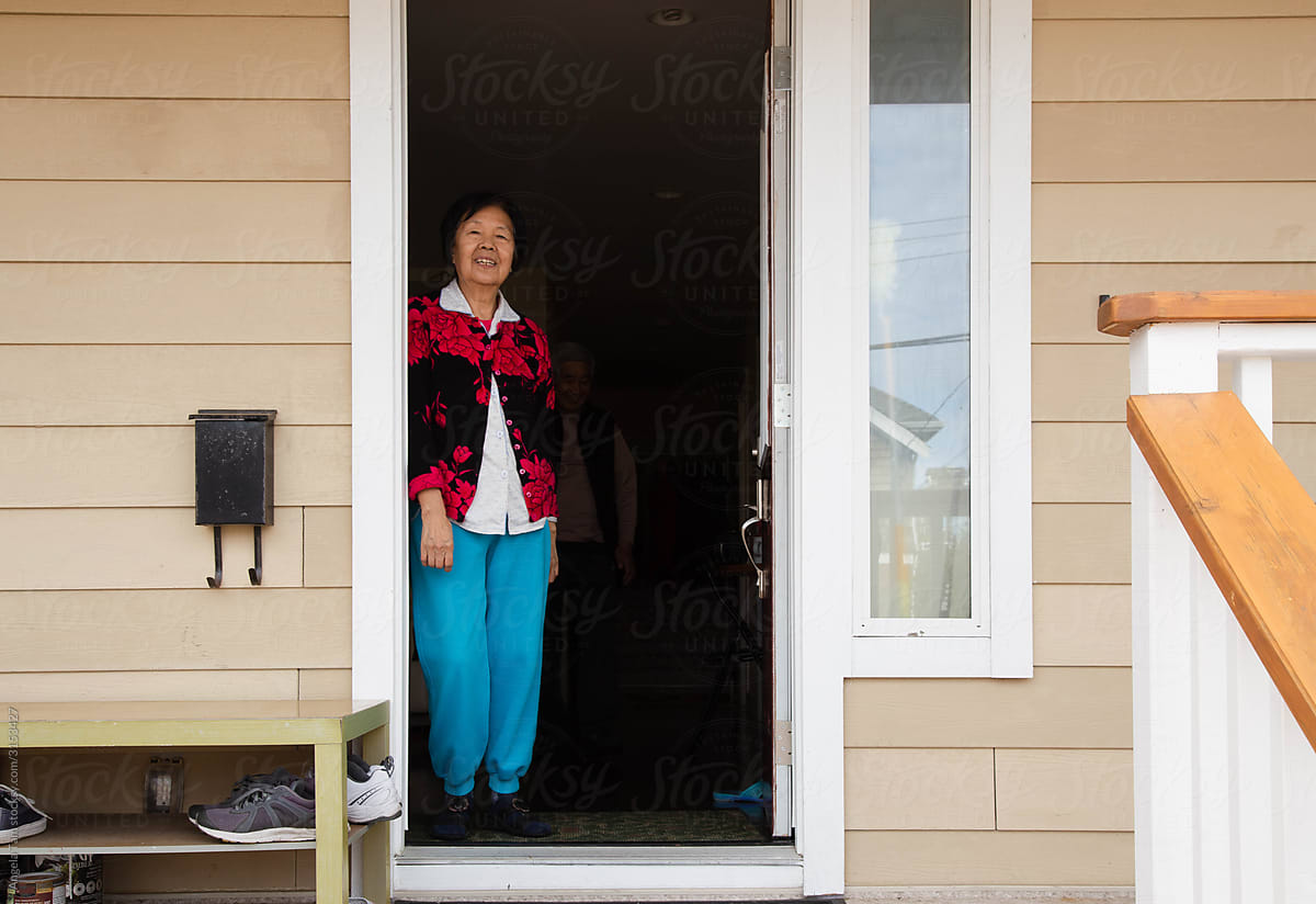 Asian elderly woman standing at the doorway