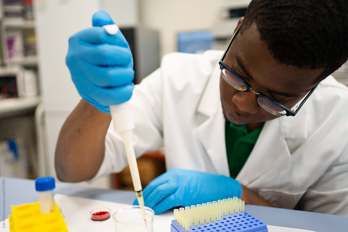 Black Man Scientist Focused Using The Pipette In The Lab.
