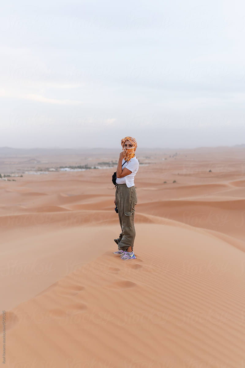 woman on top of a dune in the merzouga desert.