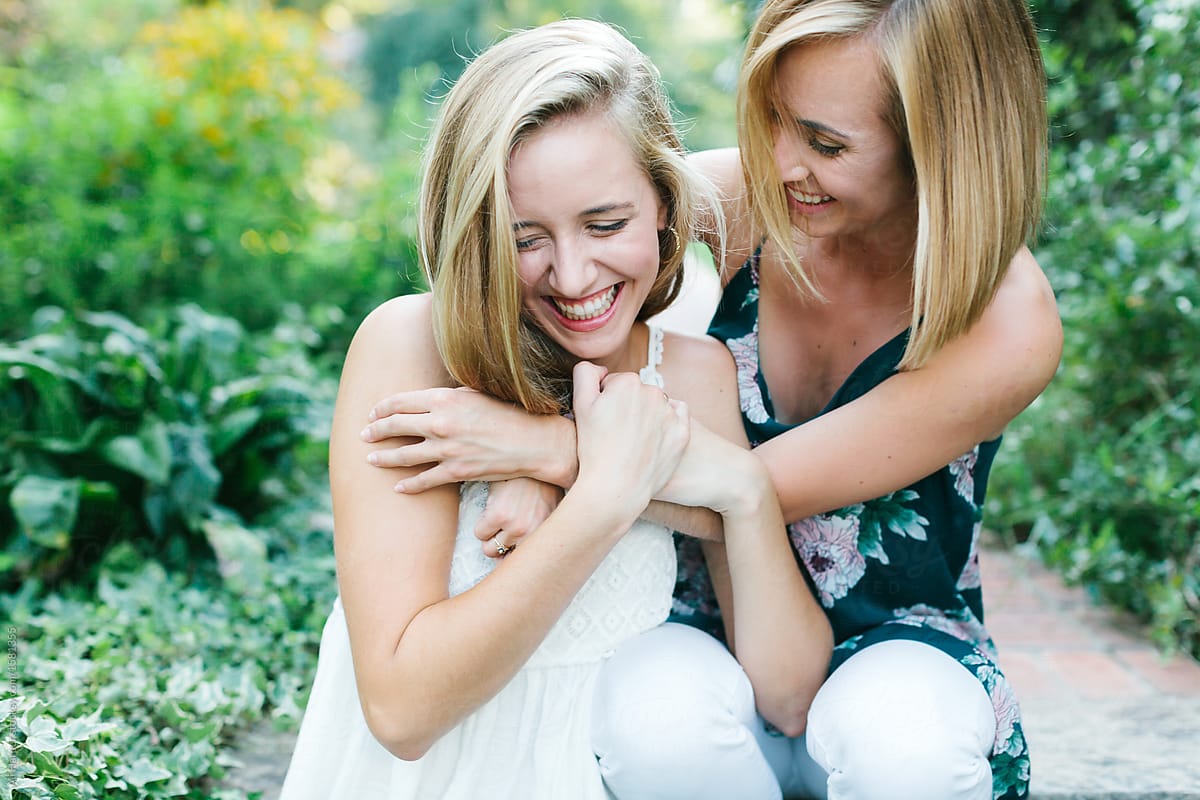 Two young girls laughing and hugging