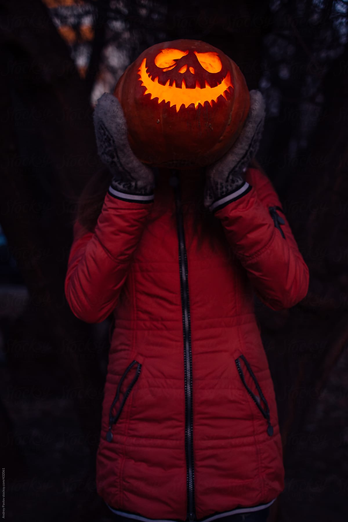 Woman with carved halloween pumpkin at head level