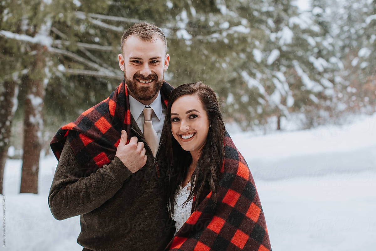 Wedding Couple Wrapped in Blanket in Winter Landscape