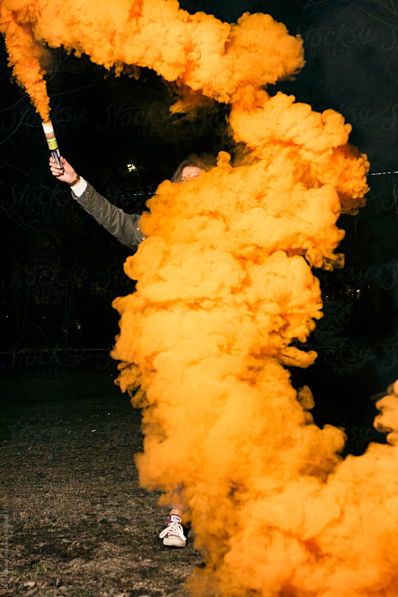 Woman holding orange smoke bomb