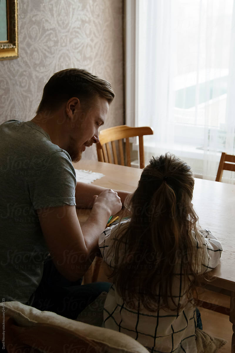 Father and daughter drawing at table together