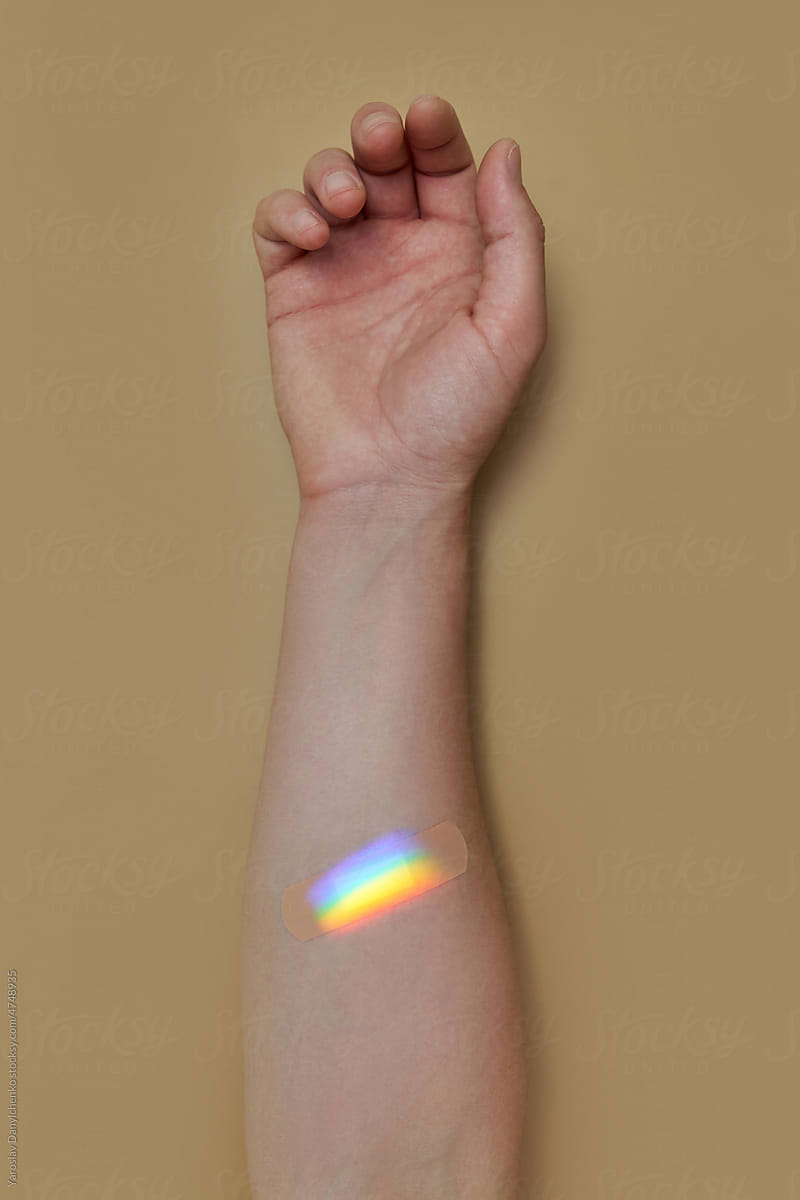 Rainbow on adhesive bandage on person\'s skin.