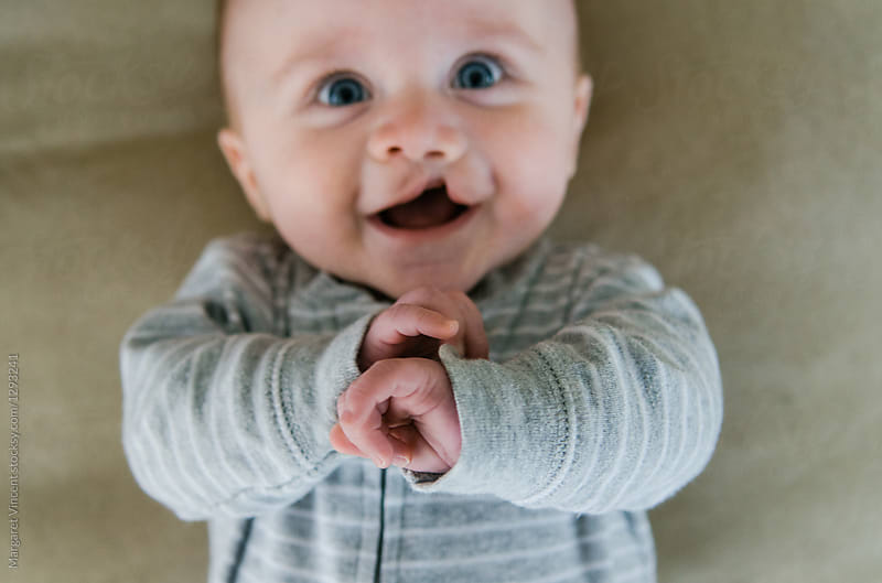 happy, blurry baby with focus on tiny fingers