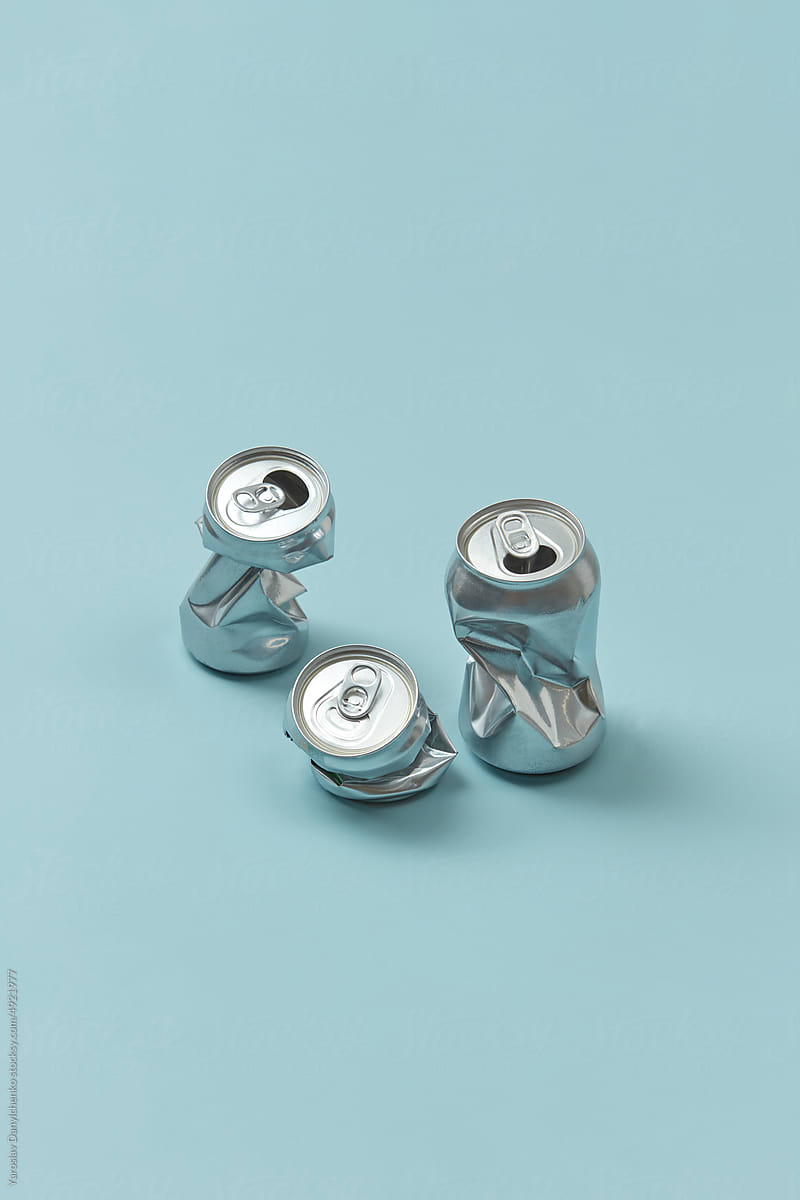 Crumpled aluminum cans on blue background.