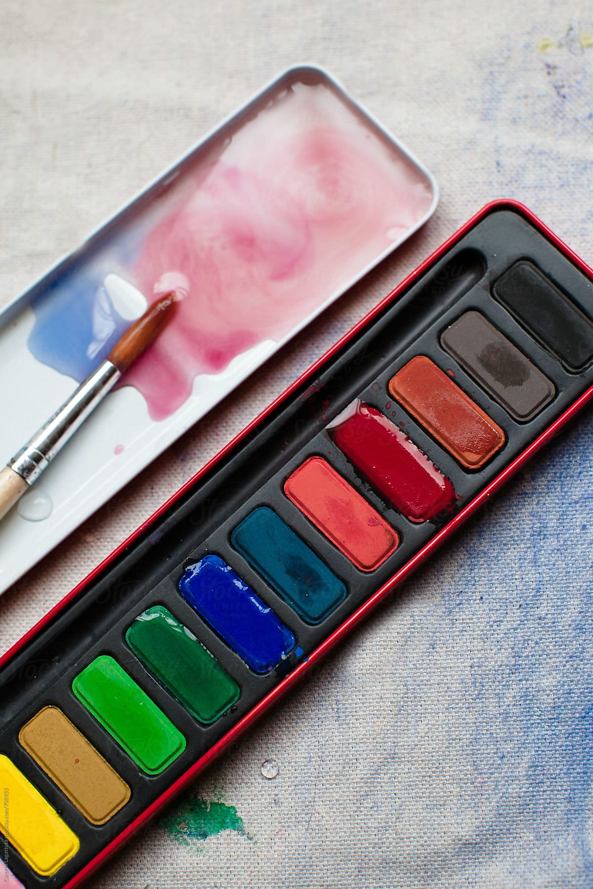 Palette of paints and a paint brush on a canvas