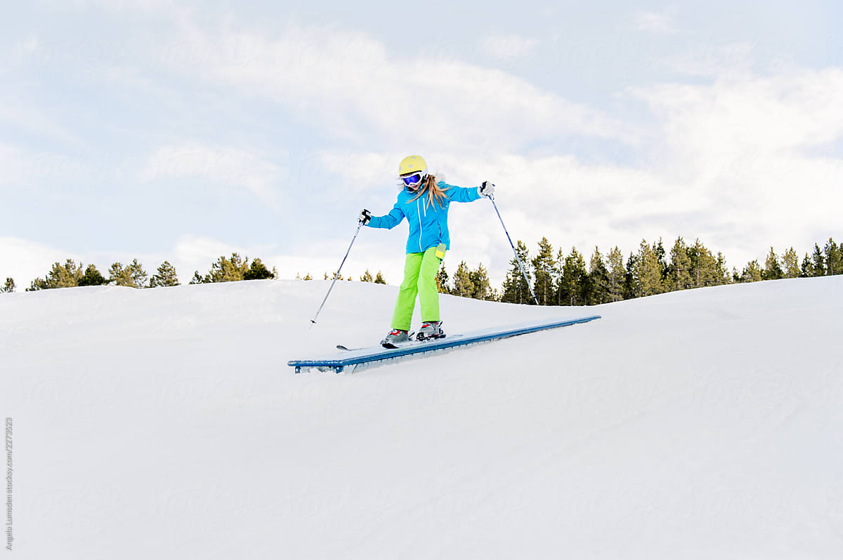 Pre-teenage girl skiing in a small terrain park in winter