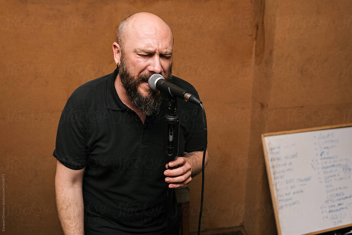 Bearded singer performing song with microphone