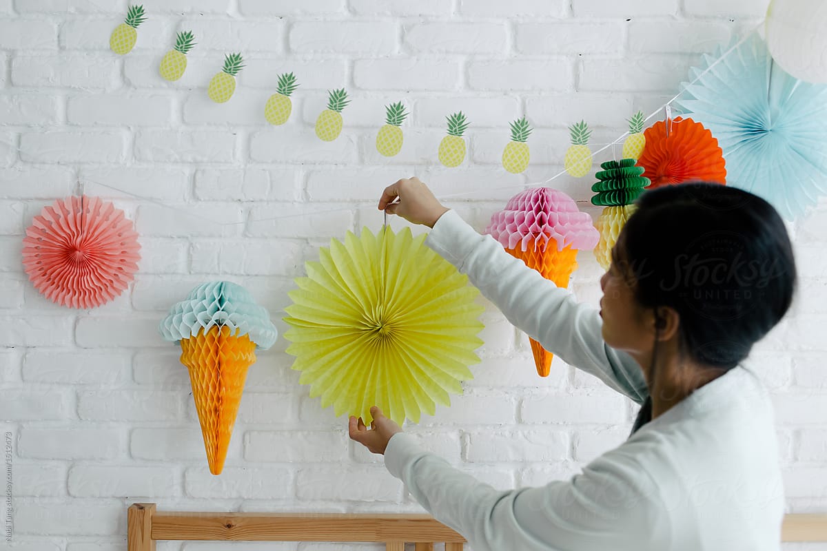 Asian young woman decorating house with multicolored diy tissue paper decoration lantern