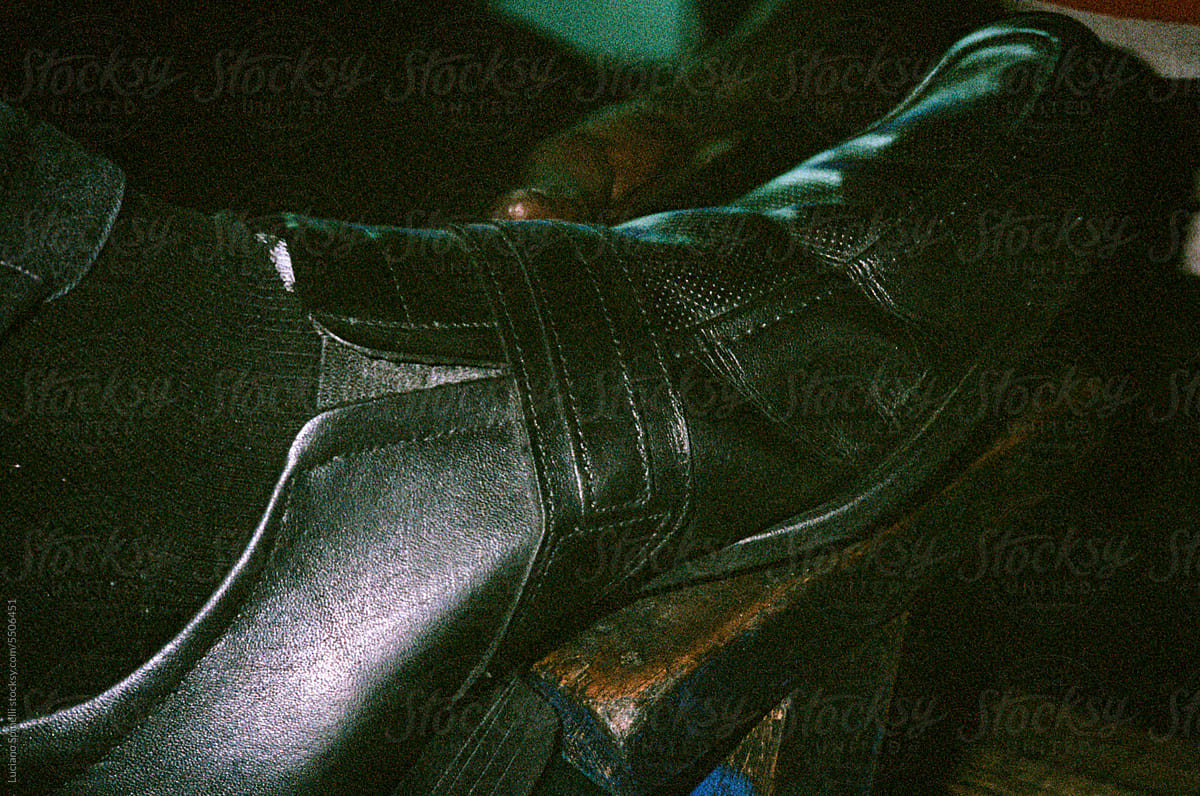 Detail of shoe being polished by shoe shiner in the street at night