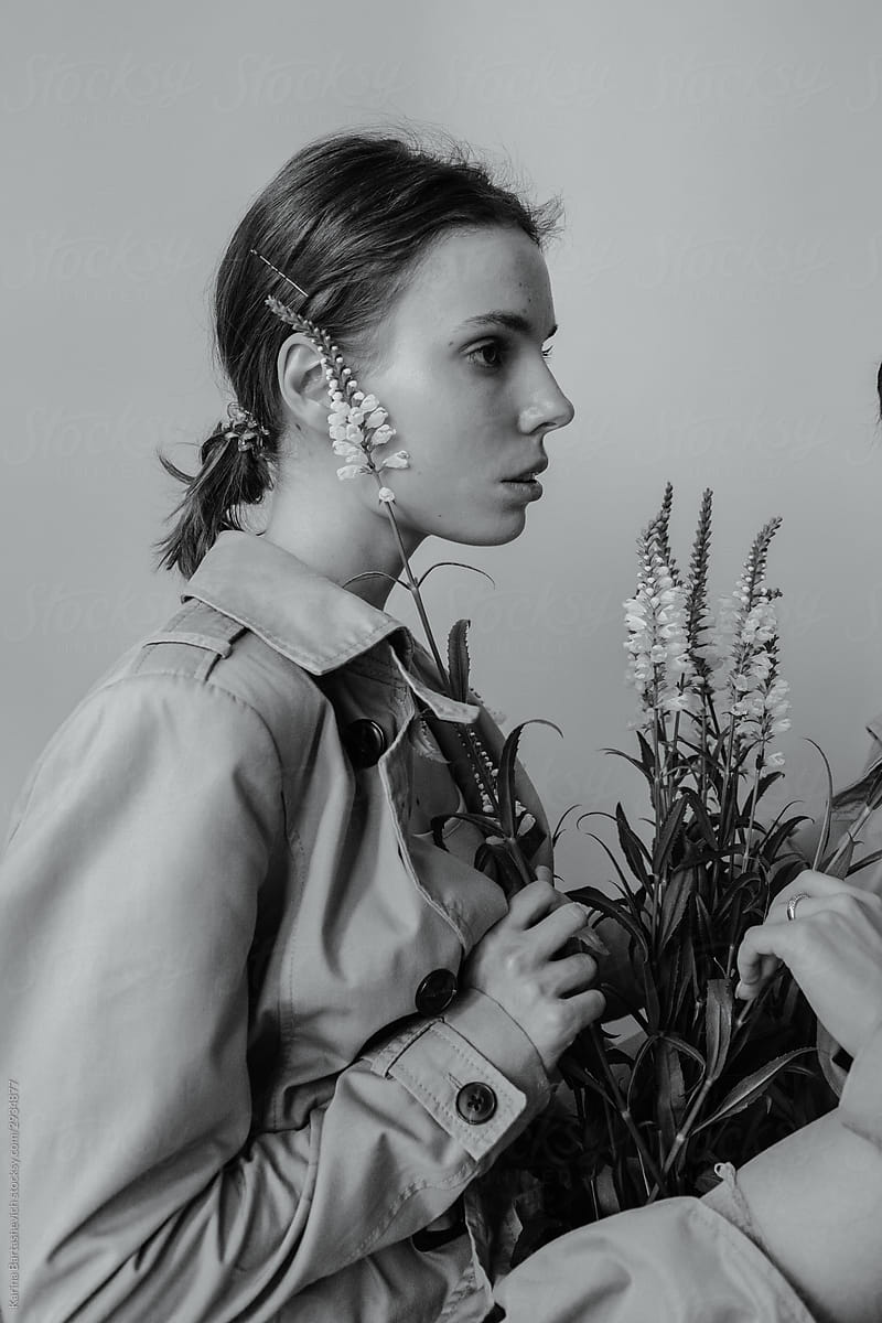 black and white portrait of a girl in profile with a bouquet of flowers in hands