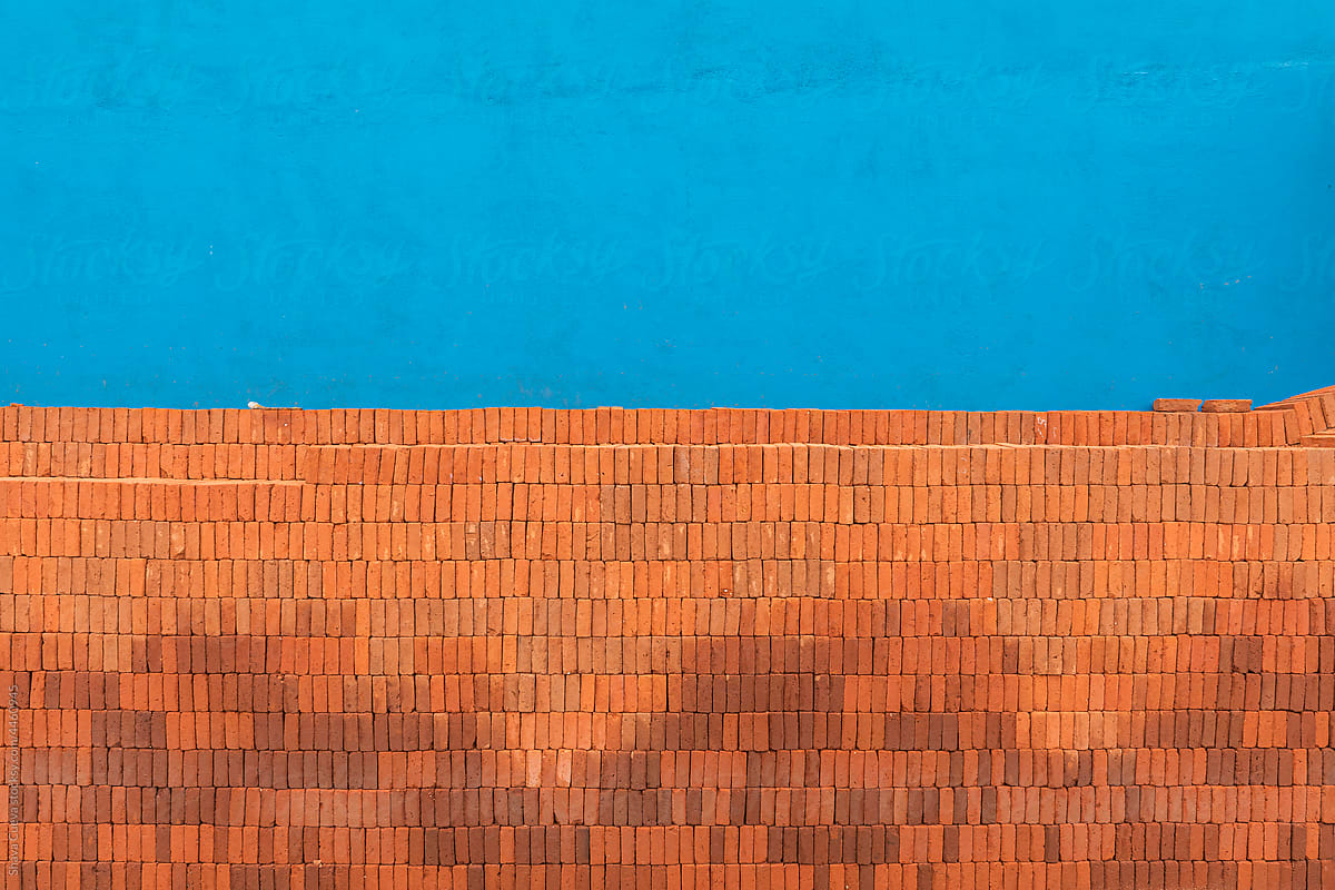 Stacked bricks in front of a blue colored wall