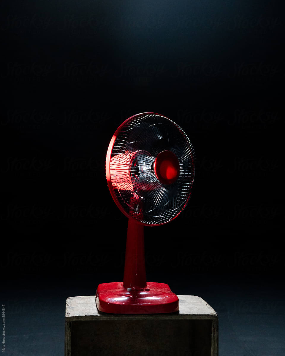Portrait of a red fan on a wooden box in home stock photography studio