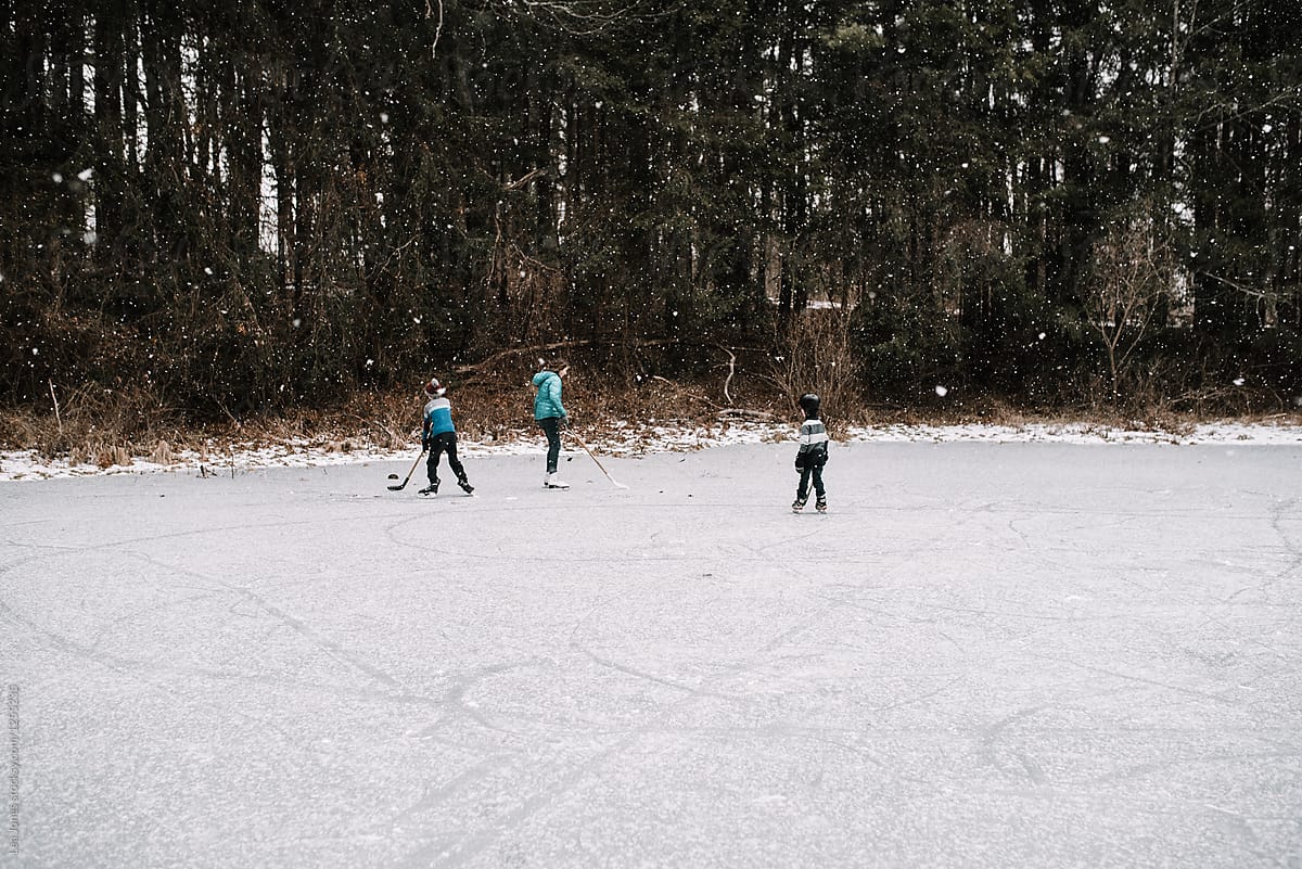 kids playing hockey on frozen pond