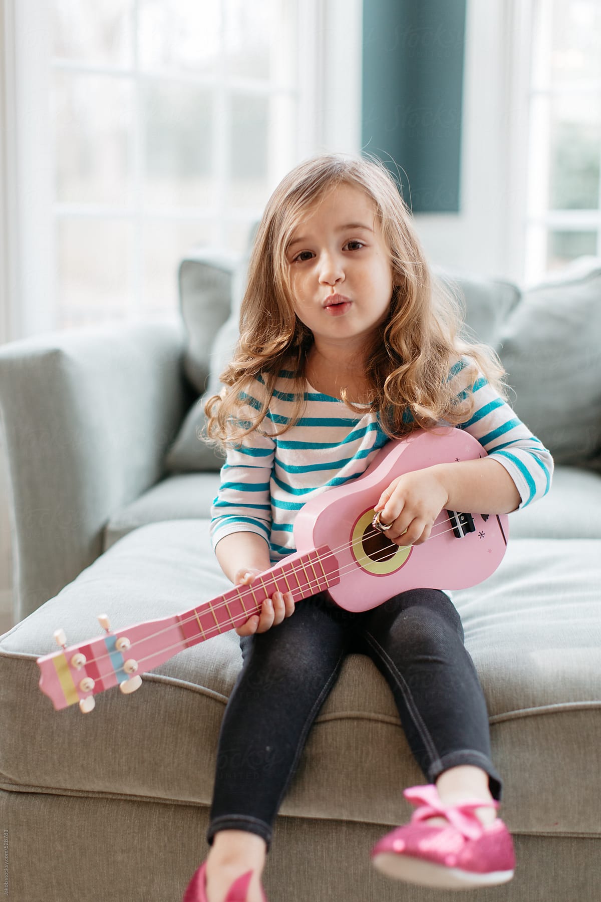 Cute toddler playing a toy guitar and singing a song