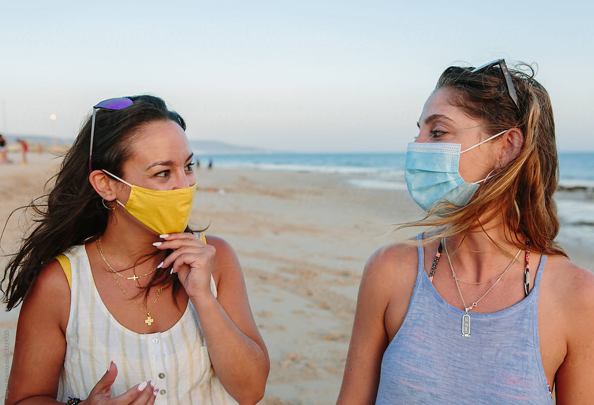 Two friends chatting wearing facemasks