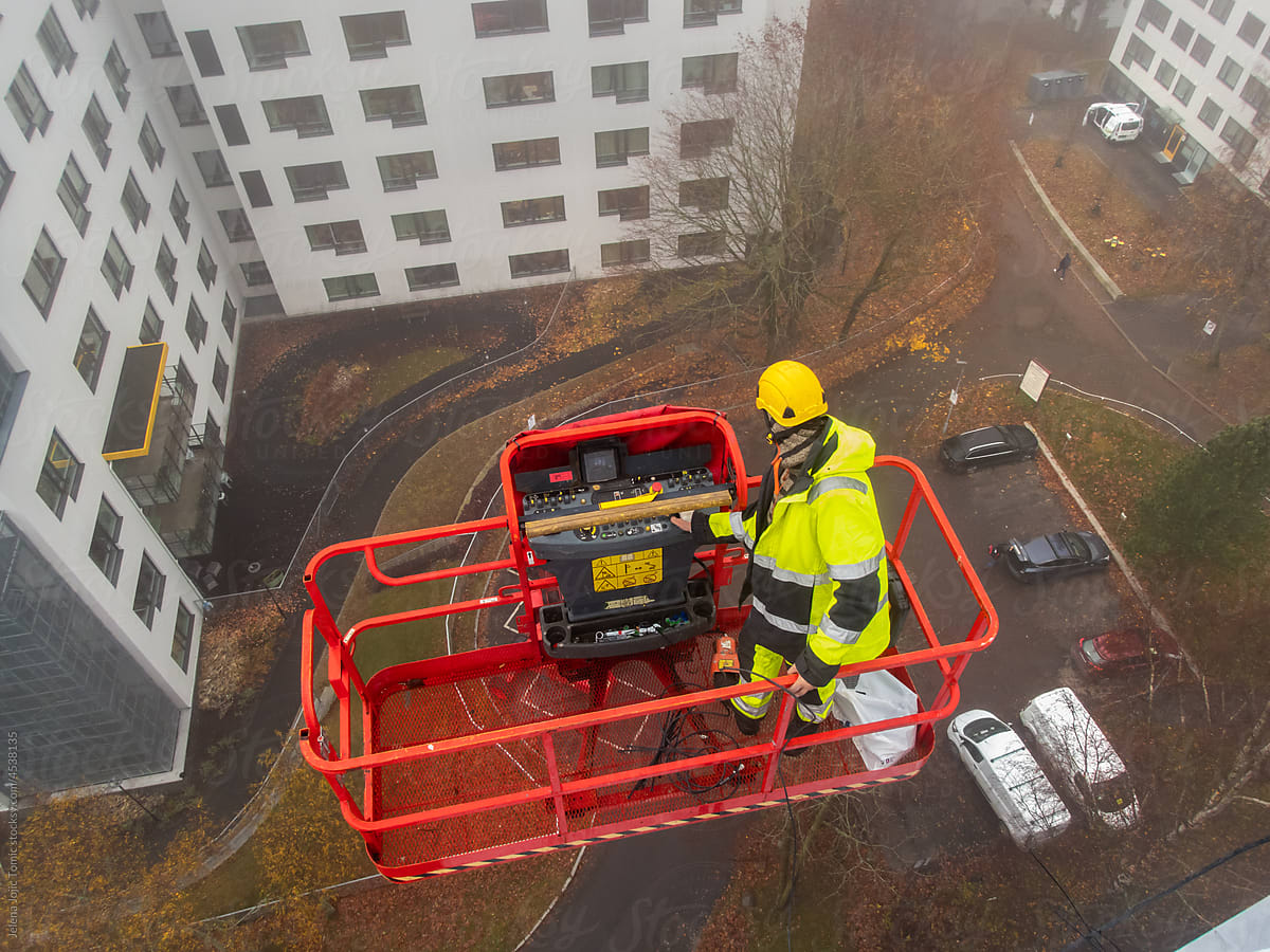 5G network installation, technicians work on a building using the lift