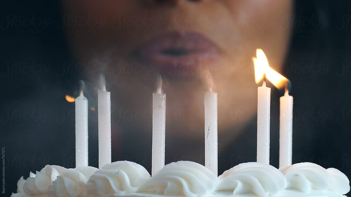Close Up On Candles As Woman Blows Out Flames