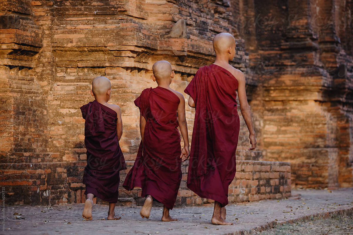 Novice monks walking by ancient pagoda