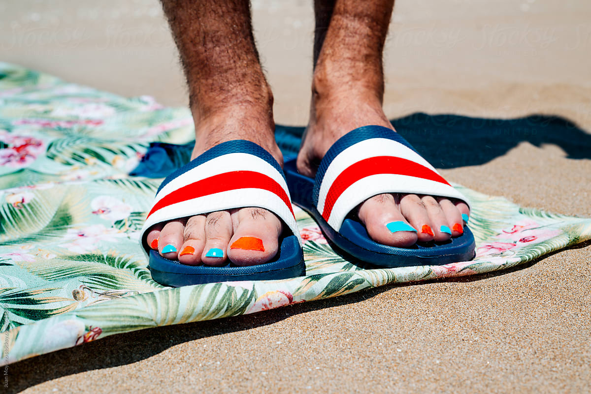 man wearing sandals with colorful toenails