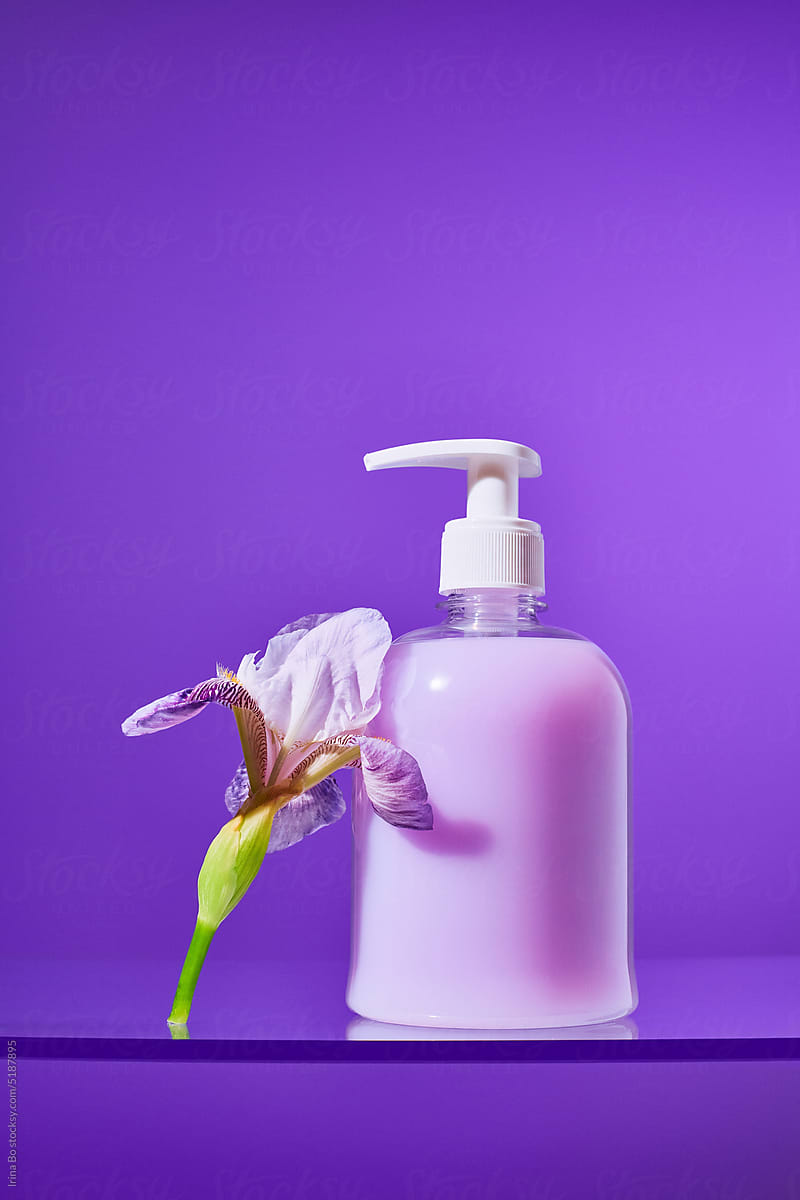 Bottle of liquid purple soap with a flower