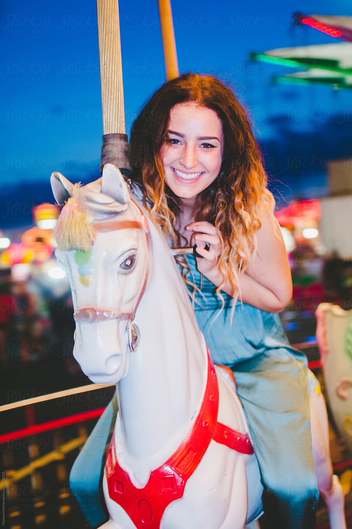 A young woman on a carousel at the carnival