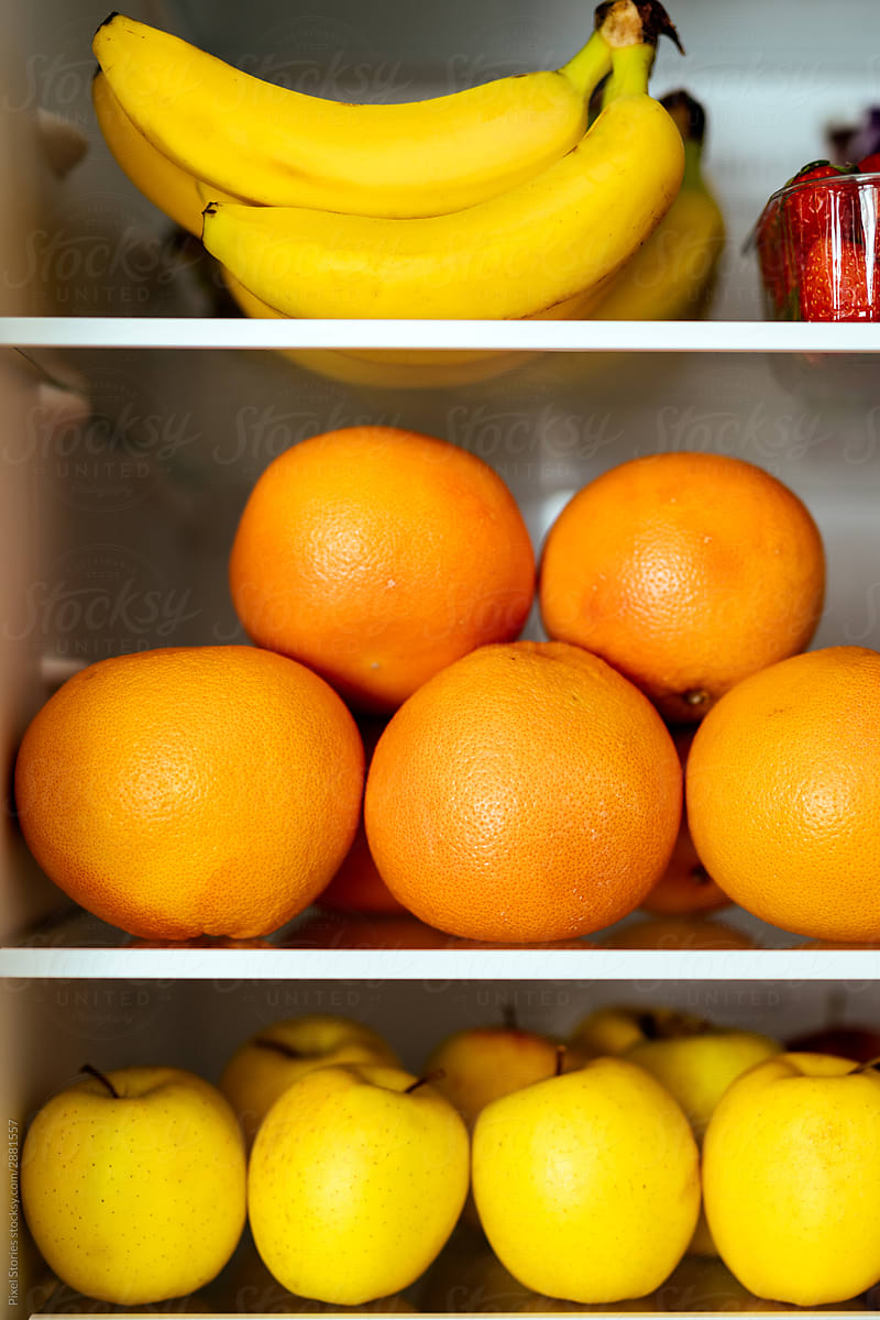 Fruits  on shelves in an open refrigerator