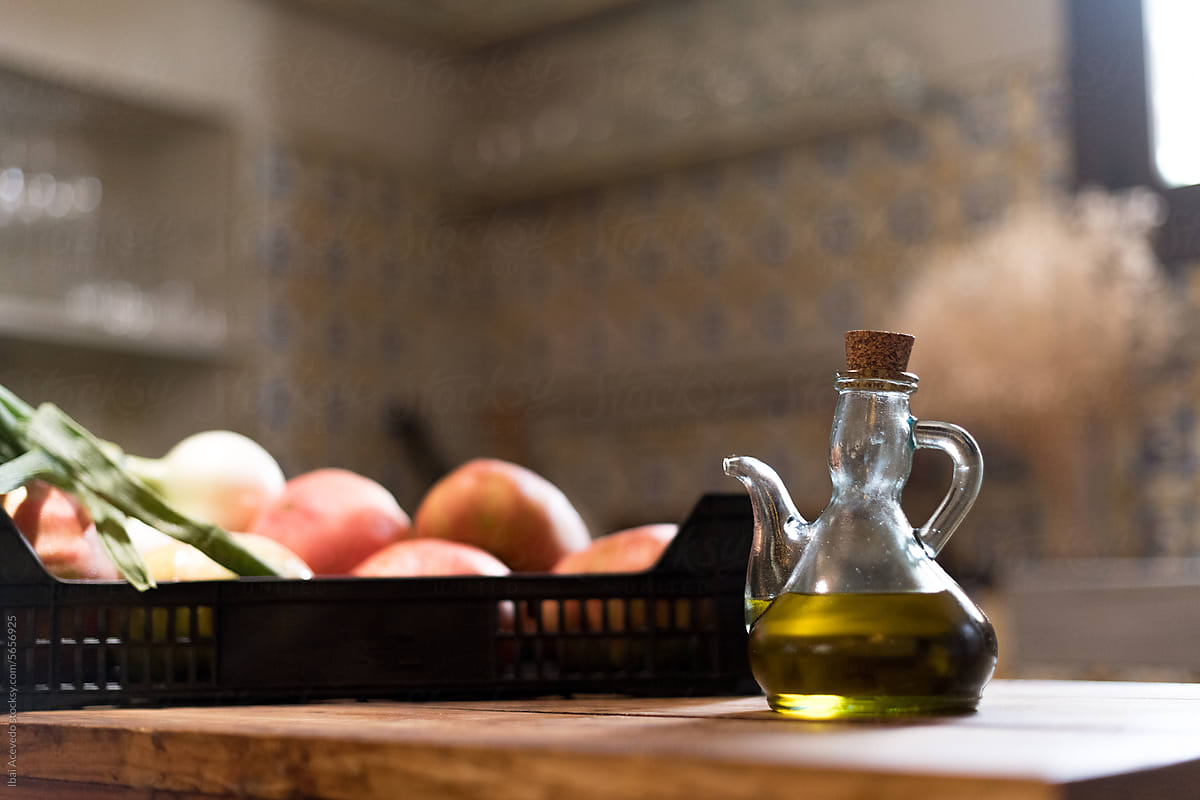 Olive oil and fresh vegetables on rustic table