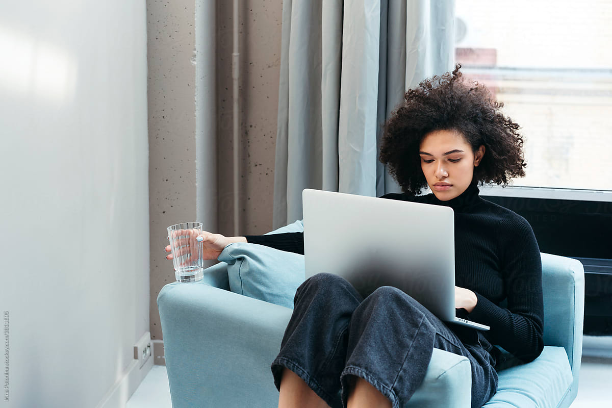 Black female freelancer using laptop.